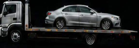 Silver sedan on a flatbed tow truck