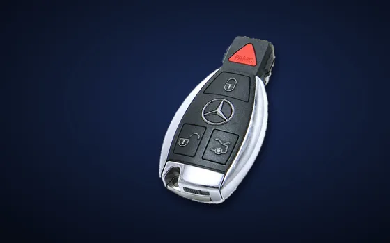 Genuine Mercedes-Benz smart key with the chrome star on a dark blue background