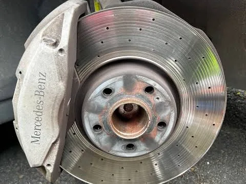 Worn Mercedes-Benz drilled brake rotor with a raised lip on the outer edge