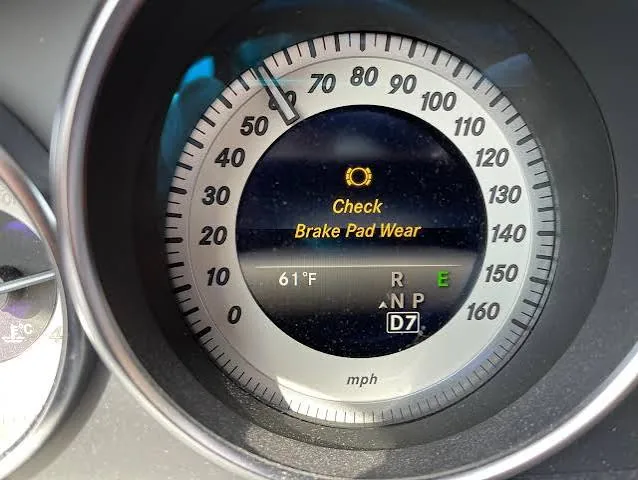 Older Mercedes-Benz cluster showing the Check Brake Pad Wear message in the speedometer